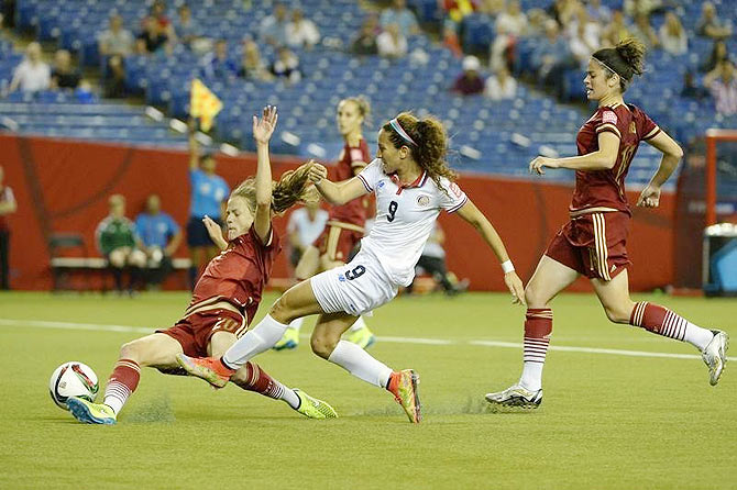 England midfielder Jill Scott (8) goes up for a header against France's Amandine Henry (left) and Gaetane Thiney (17) during their Group F match at Moncton Stadium in New Brunswick, on Tuesday