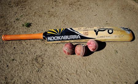 A Compton Homies bat and balls lie on the cricket grounds during a training session