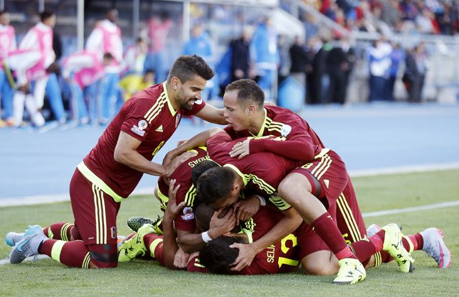 Venezuela players mob teammate Jose Rondon (obscured) as they celebrate his goal against Colombia during their first round Copa America match at Estadio El Teniente in Rancagua, Chile on Sunday