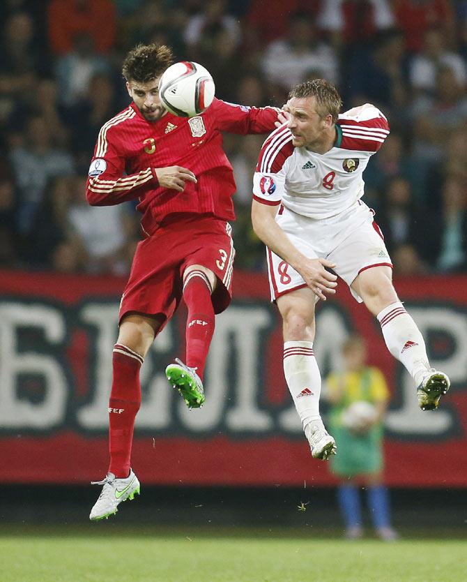 Spain's Gerard Pique (left) and Belarus's Sergei Kornilenko jump for a header during their Euro 2016 Group C qualifying match at the Borisov Arena stadium outside Minsk, Belarus, on Sunday