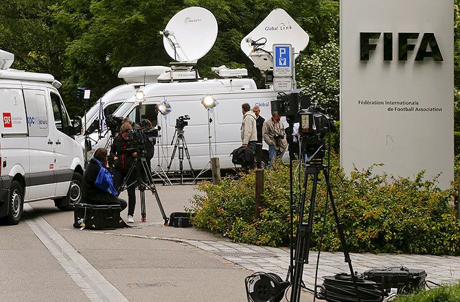 Members of the media stand in front of the entrance of the FIFA headquarters in Zurich