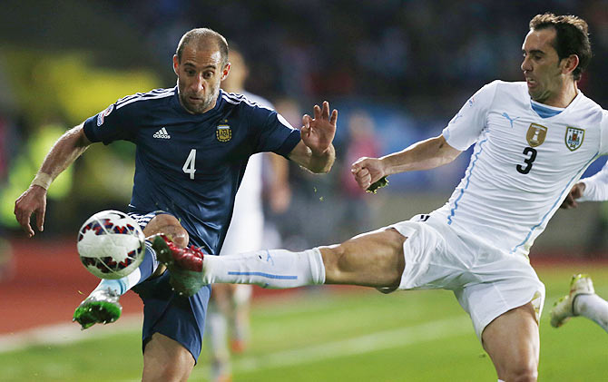 Argentina's Pablo Zabaleta is tackled by Uruguay's Diego Godin (right)