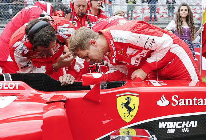 Ferrari Formula One driver Sebastian Vettel of Germany looks into his car after the Austrian F1 Grand Prix at the Red Bull Ring circuit in Spielberg, Austria, on Sunday