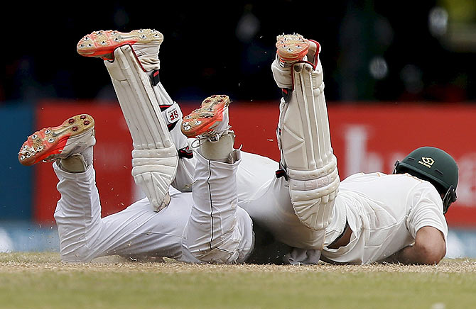 Pakistan's Ahmed Shehzad (top) collides with Sri Lanka's Kaushal Silva as he tries to make his ground on the third day of their second Test in Colombo on June 27