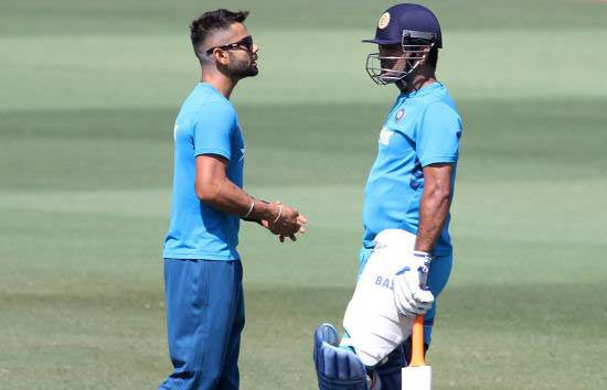 Virat Kohli (left) speaks to India captain Mahendra Singh