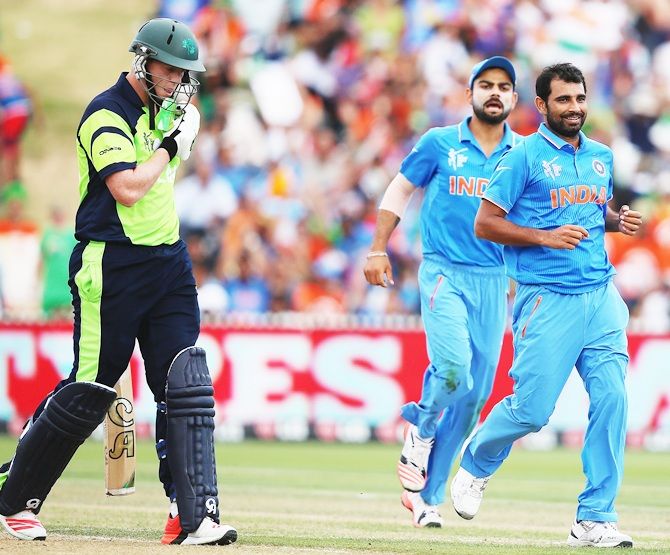Mohammed Shami and Virat Kohli exult after taking Kevin O'Brien's wicket. Photograph: Hannah Peters/Getty
