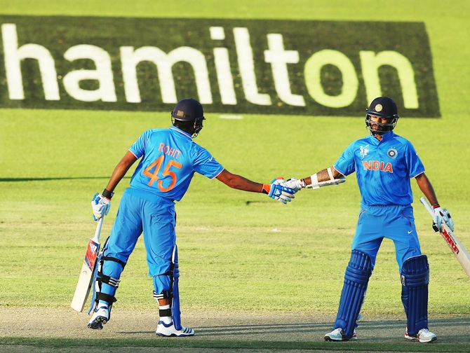 Rohit Sharma and Shikhar Dhawan mark their 100 run partnership. Photograph: Hannah Peters/Getty Images