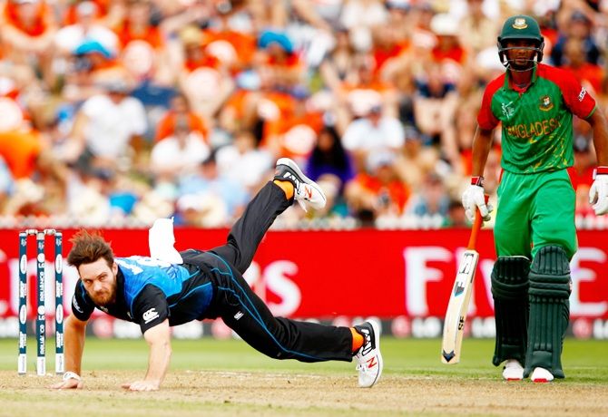 Mitchell McClenaghan of New Zealand falls while bowling