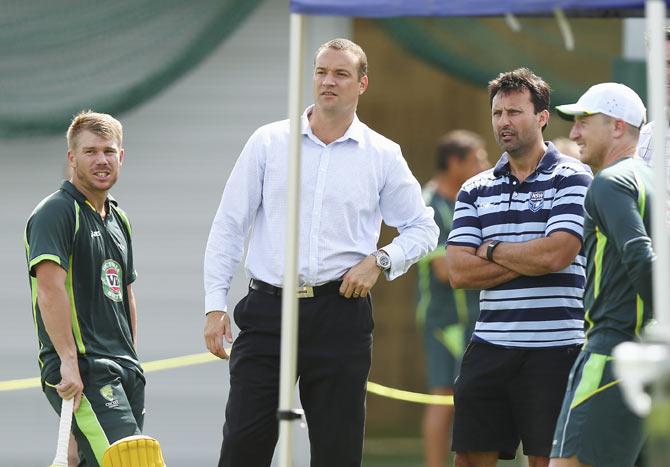 David Warner of Australia speaks with former Test cricketer Stuart Clark and Laurie Daley, NSW State of Origin Coach, during an Australian nets session on Tuesday