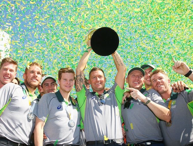 The Australian cricket team pose with the trophy at Federation Square in Melbourne 