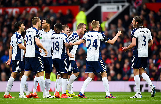 Chris Brunt (centre) of West Brom celebrates after taking a free-kick which was deflected off teammate Jonas Olsson (right) to score the opening goal against Manchester United during their English Premier League match at Old Trafford, in Manchester on Saturday