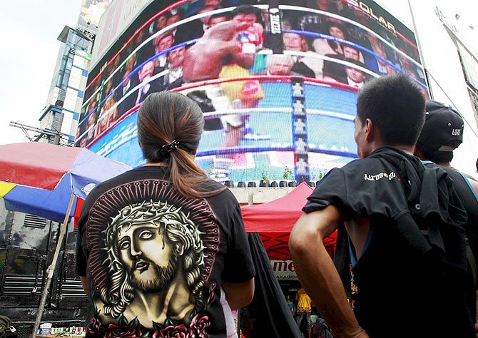 A woman reacts while watching the fight of Manny Pacquiao of the Philippines and Floyd Mayweather of US on a live telecast monitor inside a gym in Manila on Sunday