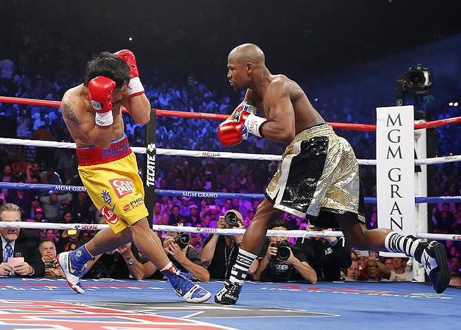 Floyd Mayweather, Jr. of the U.S. goes after Manny Pacquiao of the Philippines (L) in the first round during their welterweight WBO, WBC and WBA (Super) title fight in Las Vegas, Nevada, on Saturday