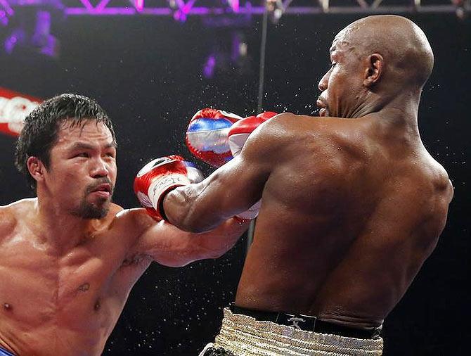 Manny Pacquiao lands a punch against Floyd Mayweather, Jr. (right)