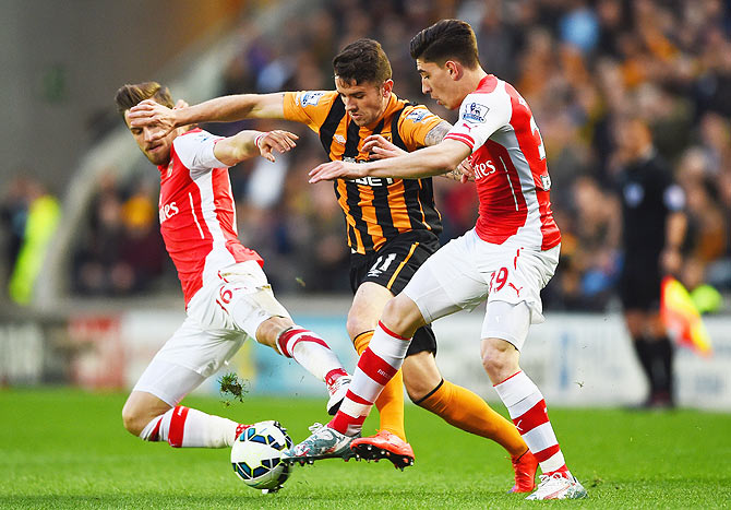 Hull City's Robbie Brady is blocked out by Arsenal's Aaron Ramsey (L) and Hector Bellerin as they vie for possession