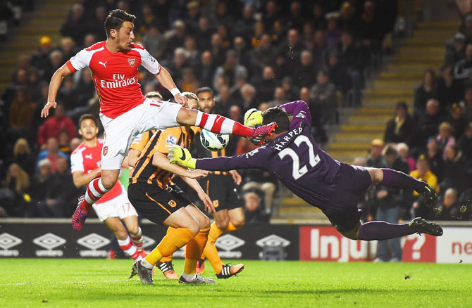 Mesut Oezil of Arsenal challenges goalkeeper Steve Harper of Hull City