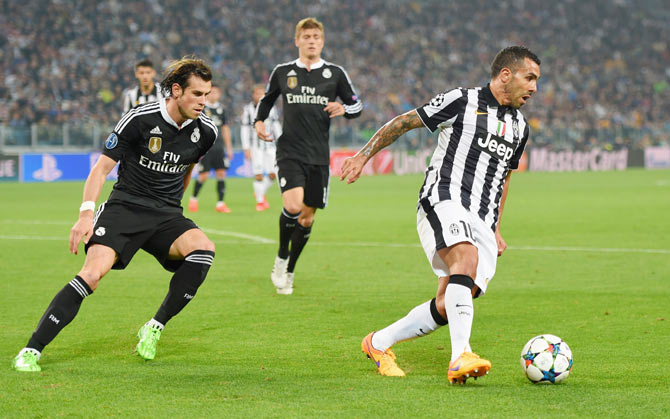 Juventus's Carlos Tevez outruns Real Madrid's Gareth Bale as they vie for possesion during their UEFA Champions League semi-final first leg match at Juventus Arena in Turin on Tuesday
