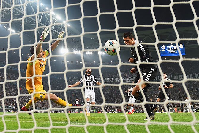 Real Madrid's Cristiano Ronaldo heads the ball past Juventus goalkeeper Gianluigi Buffon to score the equaliser.