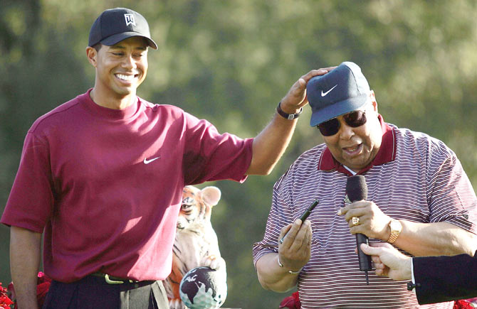 Tiger Woods (left) jokes around with his father, Earl Woods, during the trophy presentation of the Target World Challenge on December 12, 2004 at Sherwood Country Club in Thousand Oaks, California