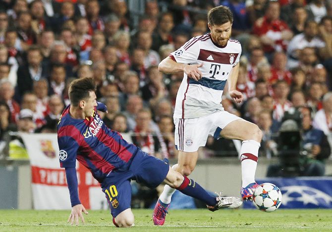 Barcelona's Lionel Messi challenges Bayern Munich's Xabi Alonso