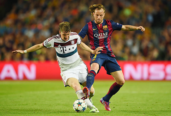 Bayern Munich's Bastian Schweinsteiger is challenged by Barcelona's Ivan Rakitic
