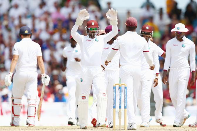 Denesh Ramdin (centre) congratulates Darren Bravo after claiming a wicket