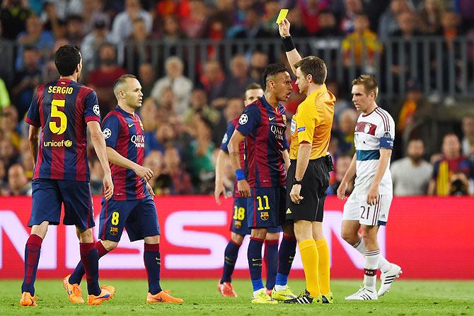 Neymar of Barcelona squares up to referee Nicola Rizzoli as he is shown the yellow card