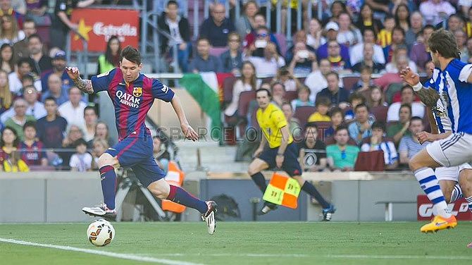 Barcelona's Lionel Messi runs with the ball past a Real Sociedad defender during their La Liga match on Sunday
