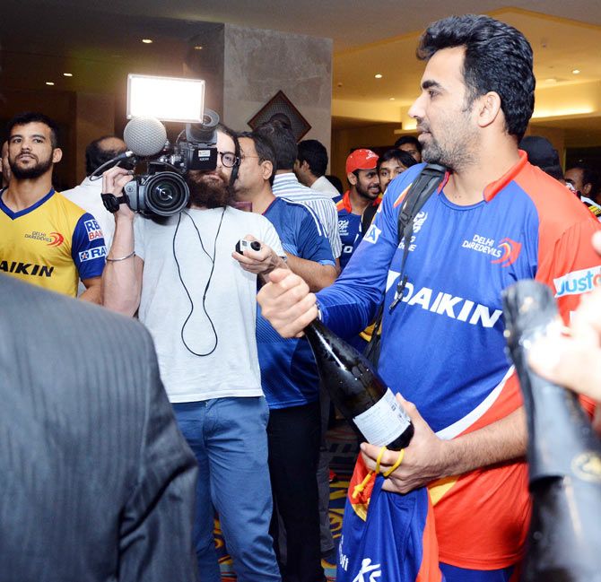 Delhi Daredevils' Zaheer Khan, who was one of the chief catalysts of the victory, prepares to pop the bubbly