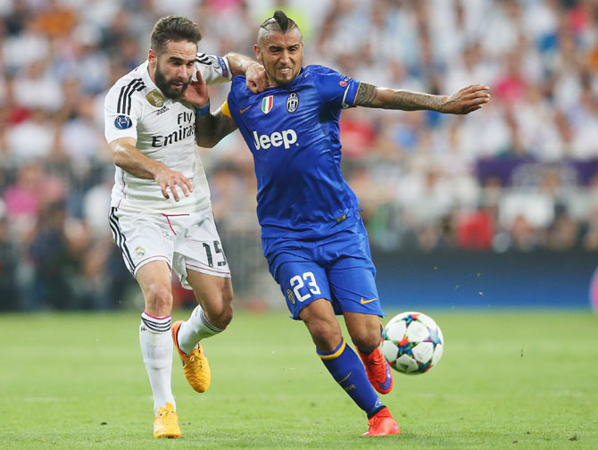 Arturo Vidal of Juventus holds off a challenge from Daniel Carvajal of Real Madrid