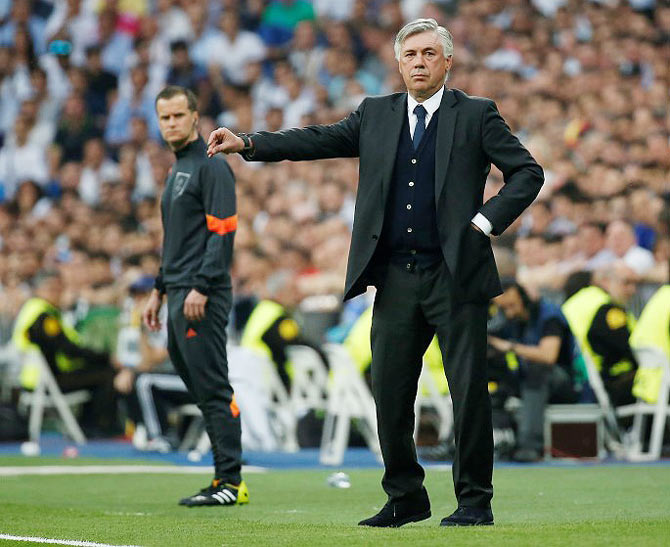 Real Madrid's Cristiano Ronaldo runs past head coach Carlo Ancelotti during a team training session