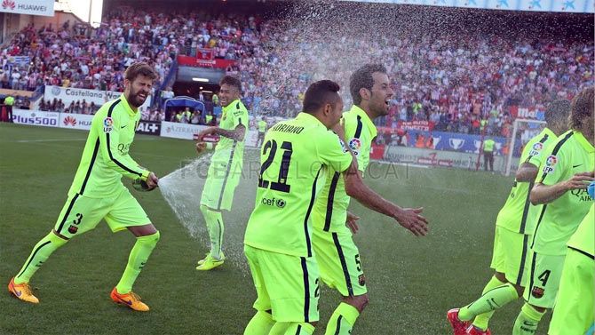 Gerard Pique pops the bubbly and drenches his teammates