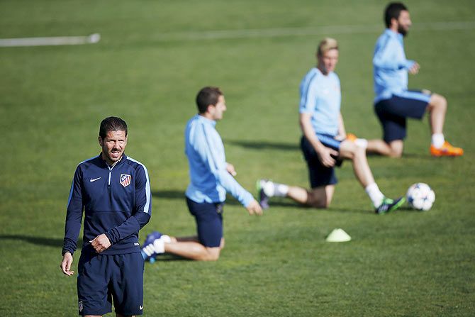 Atletico Madrid coach Diego Simeone (L) attends a training session at the club's sports grounds in Majadahonda, near Madrid