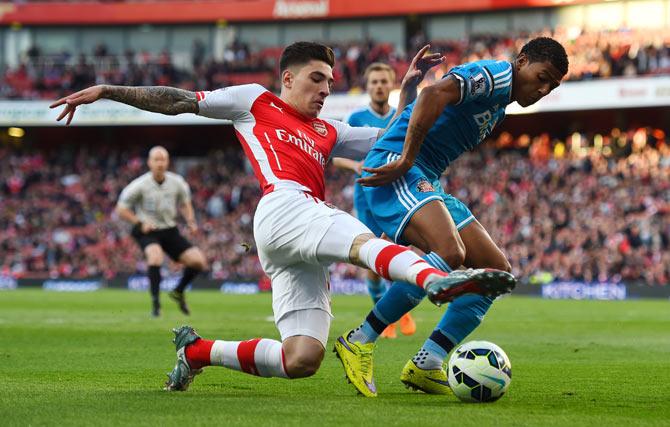 Sunderlandd's Patrick van Aanholt (right) holds off a challenge from Arsenal's Hector Bellerin