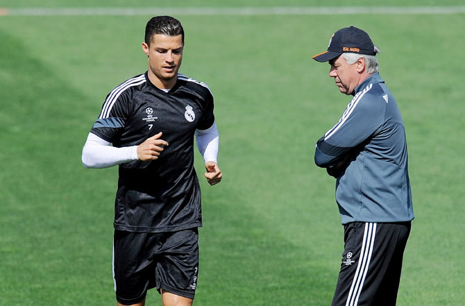 Real Madrid's Cristiano Ronaldo runs past head coach Carlo Ancelotti during a team training session