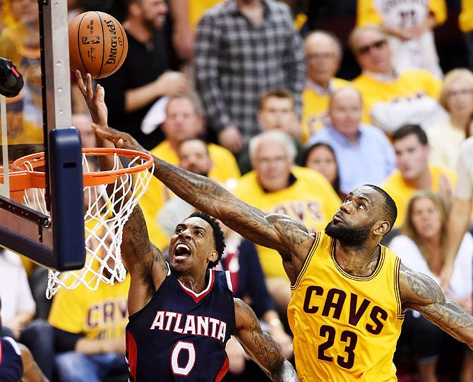 Jeff Teague #0 of the Atlanta Hawks goes up against LeBron James #23 of the Cleveland Cavaliers in overtime during Game Three of the Eastern Conference Finals