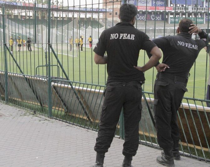 Police watch as members of the Zimbabwe cricket team practise