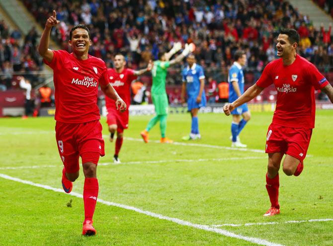 Sevilla's Carlos Bacca celebrates with teammate Vitolo after scoring his team's third goal