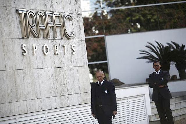 Security guards stand at the entrance of the headquarters of Traffic Sports in Sao Paulo