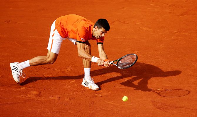 Serbia's Novak Djokovic plays a backhand during his men's singles match against Luxembourg's Gilles Muller in their 2015 French Open second round match at Roland Garros on Thursday