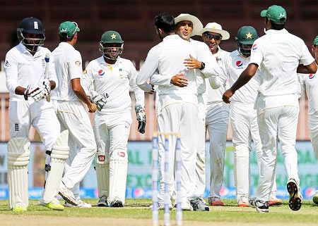 Pakistan's Shoaib Malik (C) celebrates with his team mates after taking the wicket of England's Adil Rashid
