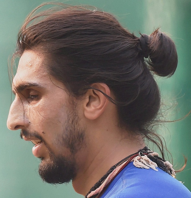 A photograph of a hipster Indian male with a braided top knot undercut in  the form of a manbraid hairstyle  Man Bun Hairstyle