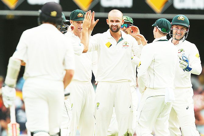 Australia's Nathan Lyon celebrates with teammates after dismissing New Zealand's Kane Williamson on day four of the first Test at The Gabba in Brisbane on Sunday