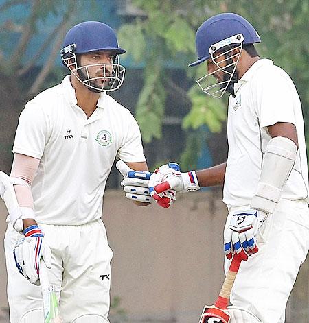 Vidarbha's Wasim Jaffer (right) celebrate his 10000 runs in Ranji Trophy cricket with teammate Faiz Yakub Fazal during their Ranji Trophy match against Bengal at Jadavpur University campus in Kolkata on Sunday