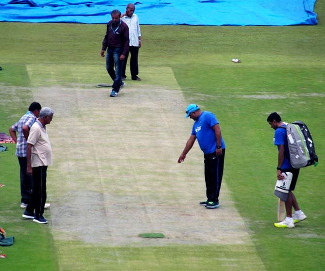 India's bowling coach Bharat Arun and spinner Ravinchandran Ashwin inspect the pitch in Bangalore on Thursday