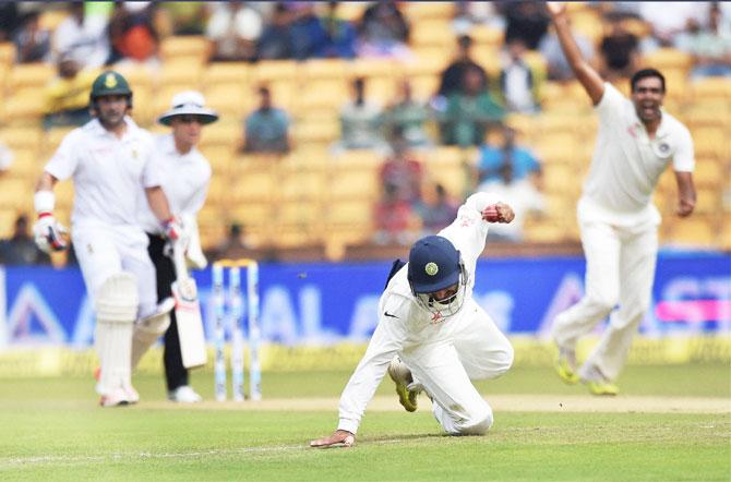 India's Cheteshwar Pujara completes a catch to dismiss South Africa's Faf Du Plesis