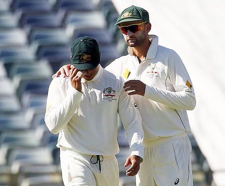 Australia's Usman Khawaja (left) is comforted by teammate Nathan Lyon after suffering an injury during the second day of the second cricket Test against New Zealand at the WACA ground in Perth on Saturday