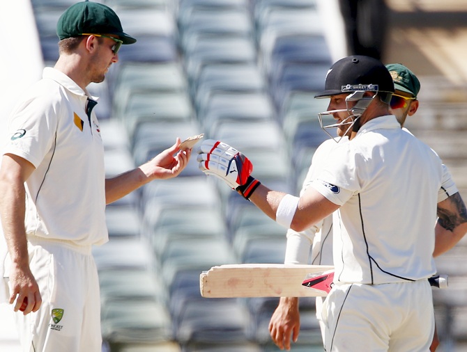  New Zealand's captain Brendon McCullum, right, takes a piece of his bat 