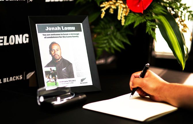 A well-wisher signs a condolence book at New Zealand Rugby Union headquarters following All Black legend Jonah Lomu's death in Wellington on Wednesday