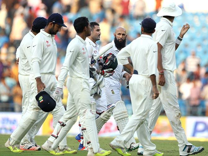 Dean Elgar and Hashim Amla of South Africa leave the field 